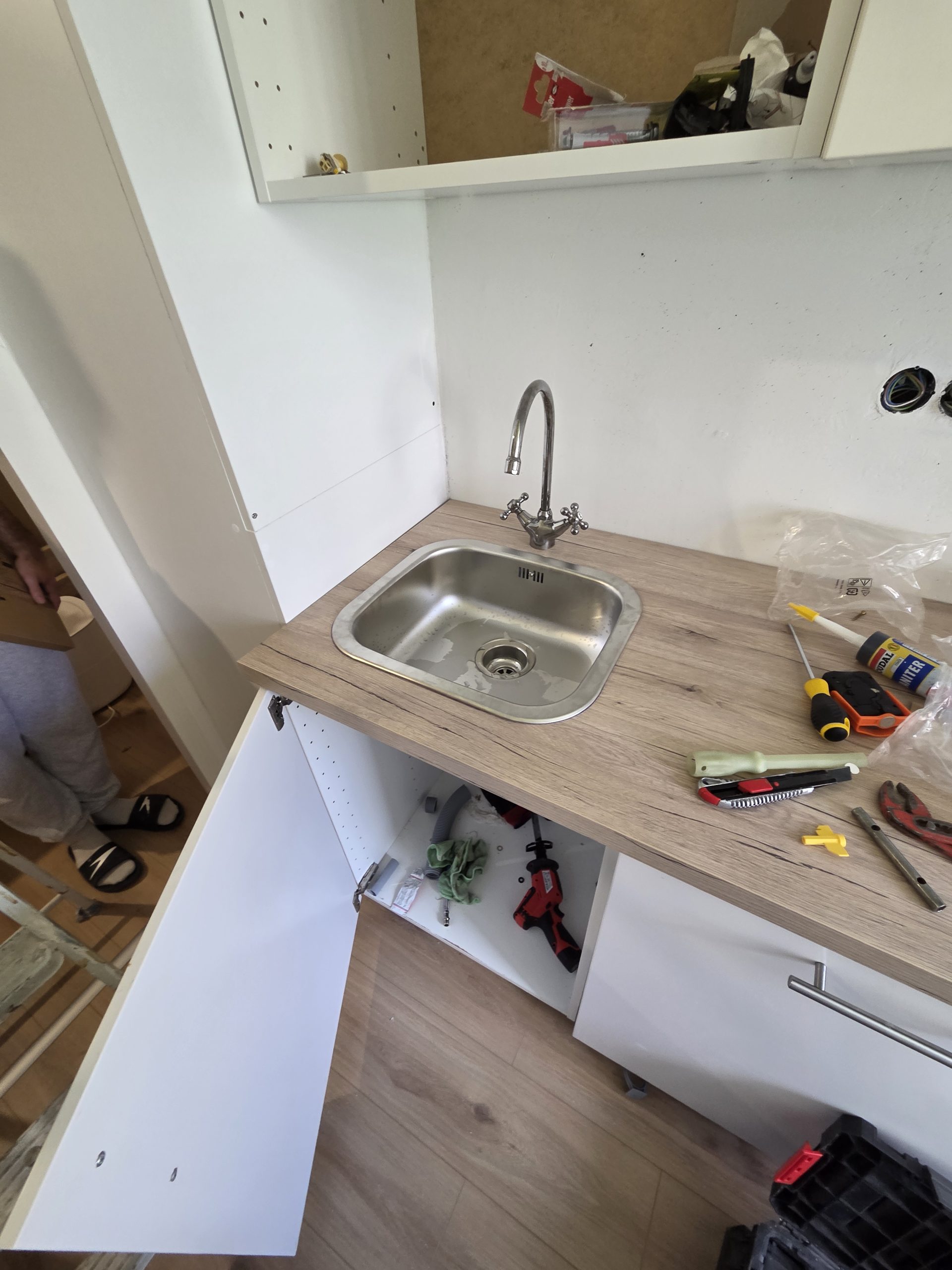 Beépített konyhai mosogató és csaptelep szerelés közben